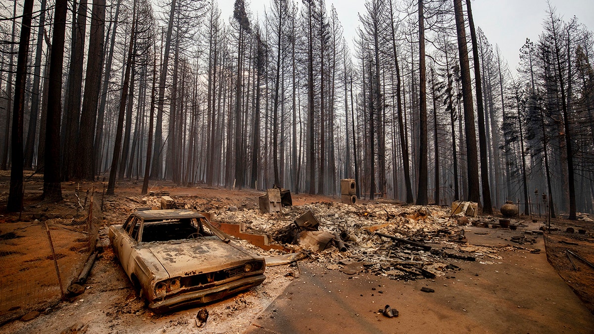 In this Aug. 17 photo, a vehicle and property are seen destroyed by the Caldor Fire in Grizzly Flats, Calif.
