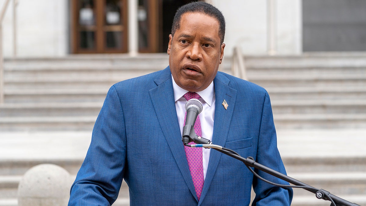 Larry Elder at lectern speaking outdoors