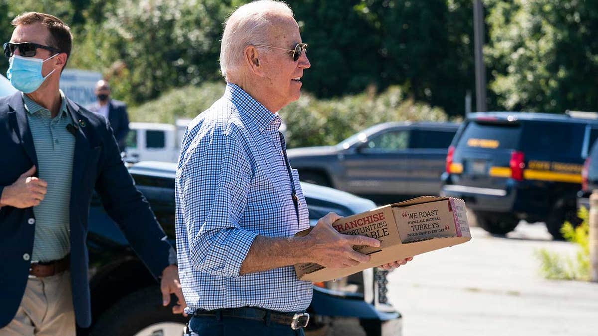 President Biden carries boxes of pizza as he pays a visit to labor union members of the International Brotherhood of Electrical Workers Local 313 in New Castle, Delaware, commemorating Labor Day, Monday, Sept. 6, 2021.