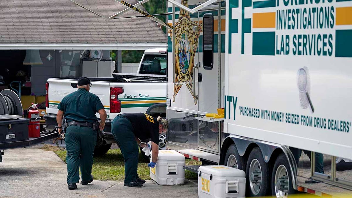 Officers from the Polk County Sheriff Department work outside Tuesday, Sept. 7, 2021, in Lakeland, Fla., at the home where a family of four was shot and killed.