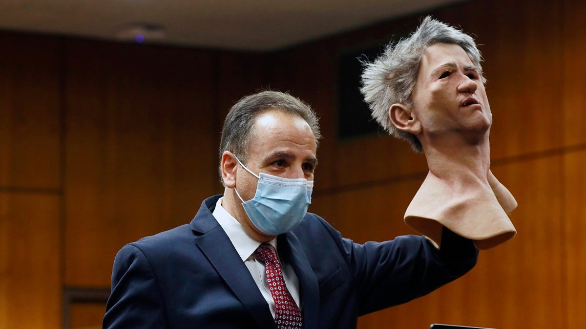 Deputy District Attorney Habib A. Balian holds a rubber latex mask, worn by Robert Durst when police arrested him. (Al Seib/Los Angeles Times via AP, Pool)