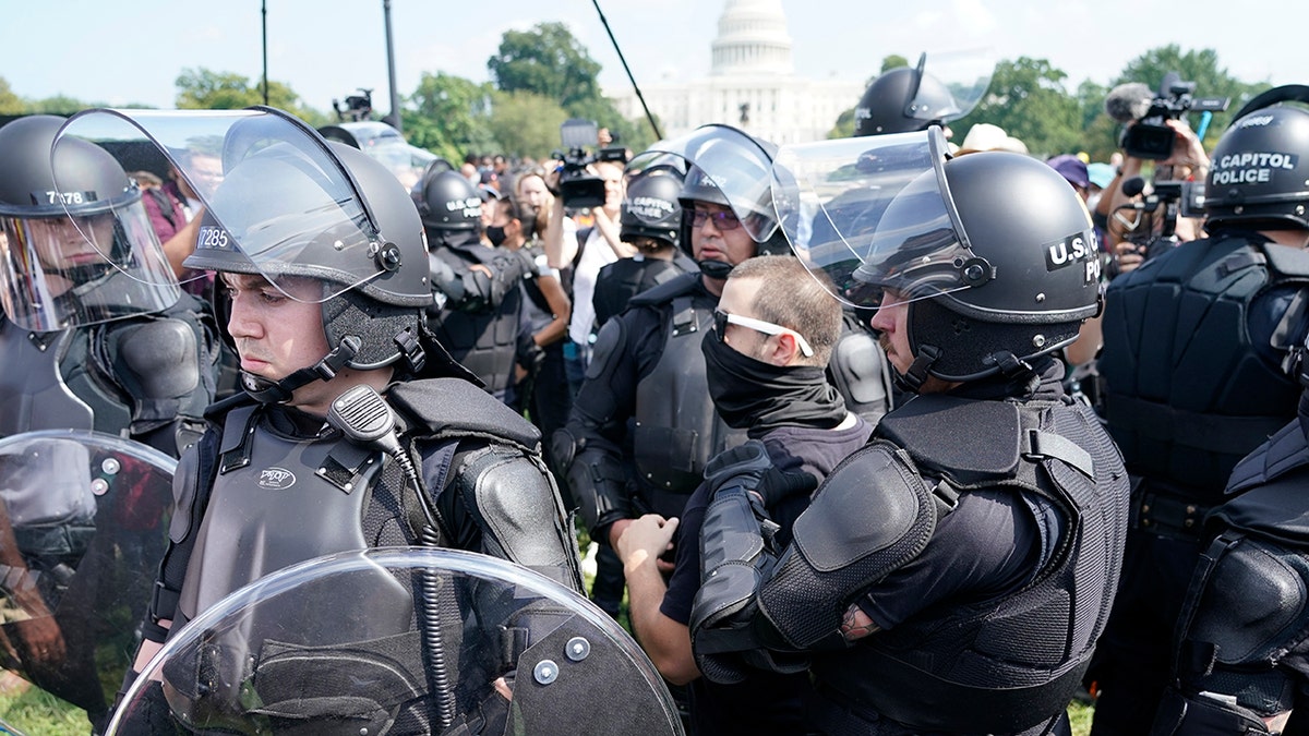 Police circle a man, center with glasses, during a rally near the U.S. Capitol in Washington, Saturday, Sept. 18, 2021. The rally was planned by allies of former President Donald Trump and aimed at supporting the so-called "political prisoners" of the Jan. 6 insurrection at the U.S. Capitol.