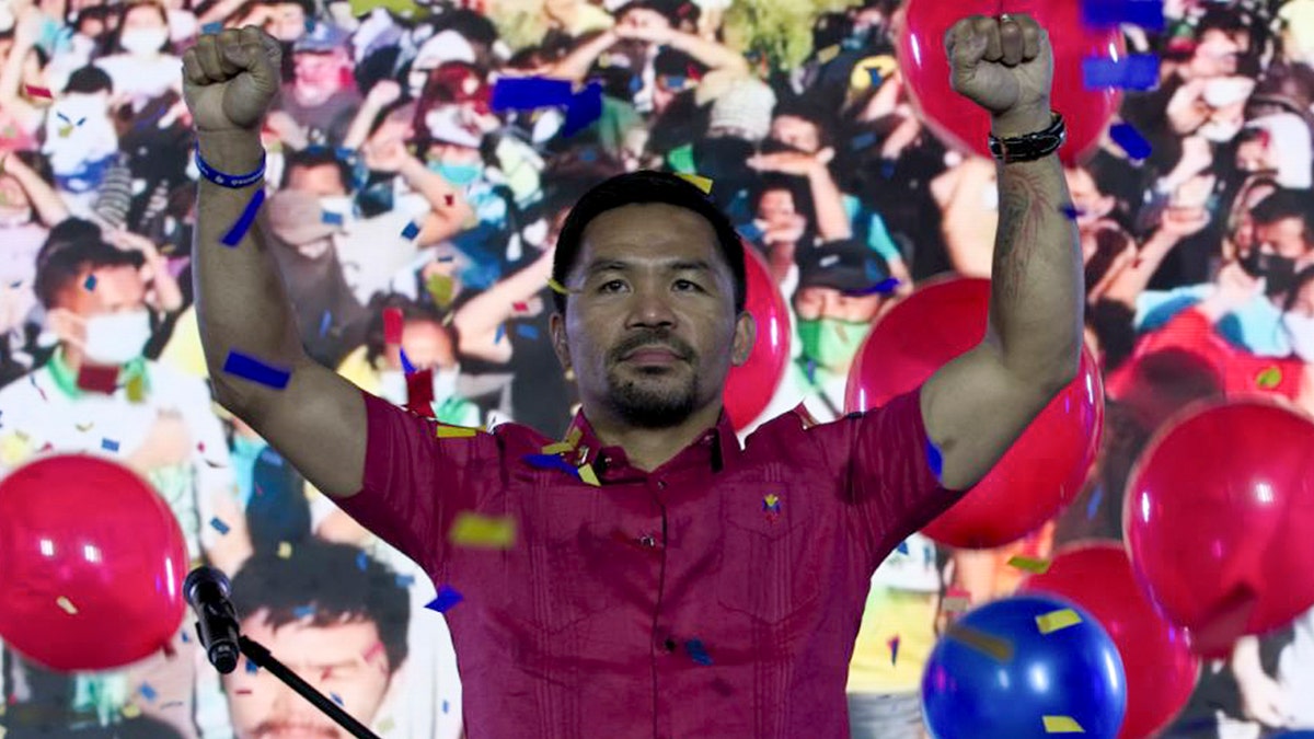 Senator Manny Pacquiao raises his hands during a national convention of his PDP-Laban party in Quezon city, Philippines on Sunday Sept. 19, 2021. (Manny Pacquiao MediaComms via AP)