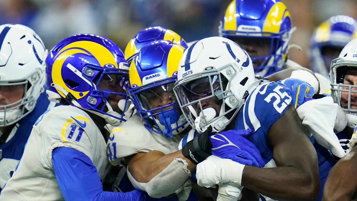 Indianapolis Colts' Marlon Mack (25) is tackled by Los Angeles Rams' Darious Williams (11) and Kenny Young (41) during the second half of an NFL football game, Sunday, Sept. 19, 2021, in Indianapolis, Ind.