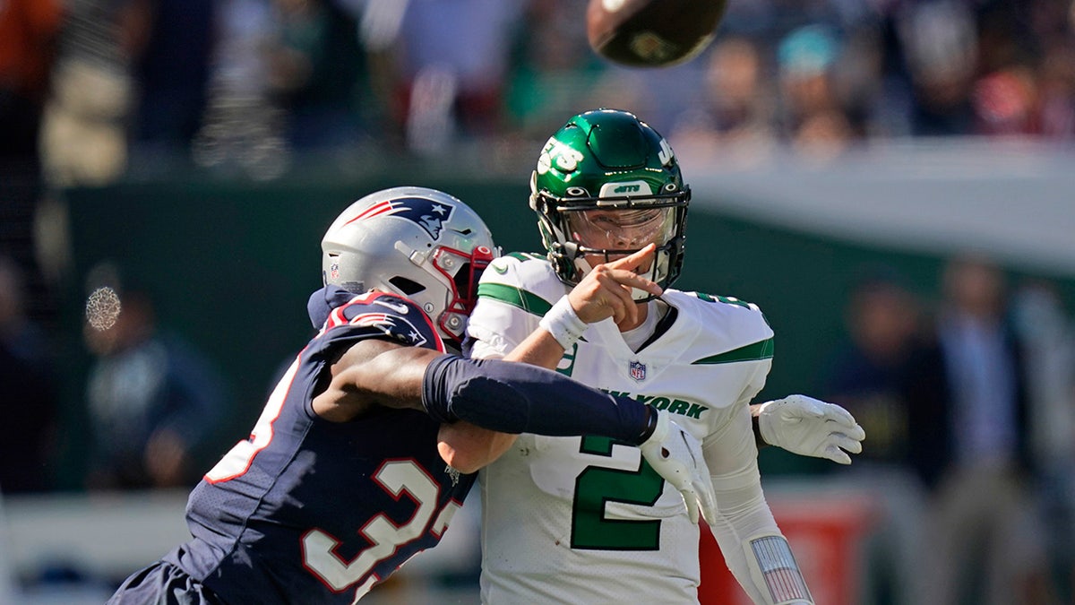 New York Jets quarterback Zach Wilson throws under pressure from New England Patriots' Joejuan Williams Sunday, Sept. 19, 2021, in East Rutherford, New Jersey. 