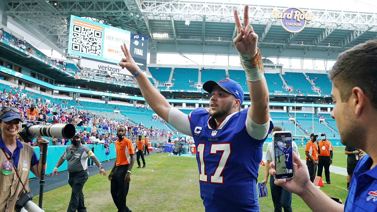 Buffalo Bills quarterback Josh Allen (17) raises his arms at the end of an NFL football game against the Miami Dolphins, Sunday, Sept. 19, 2021, in Miami Gardens, Florida. The Bills defeated the Dolphins 35-0. (AP Photo/Hans Deryk)
