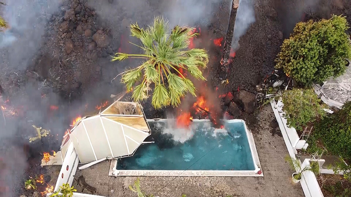 Hot lava reaches a swimming pool after an eruption of a volcano on the island of La Palma in the Canaries, Spain, Monday, Sept. 20, 2021.