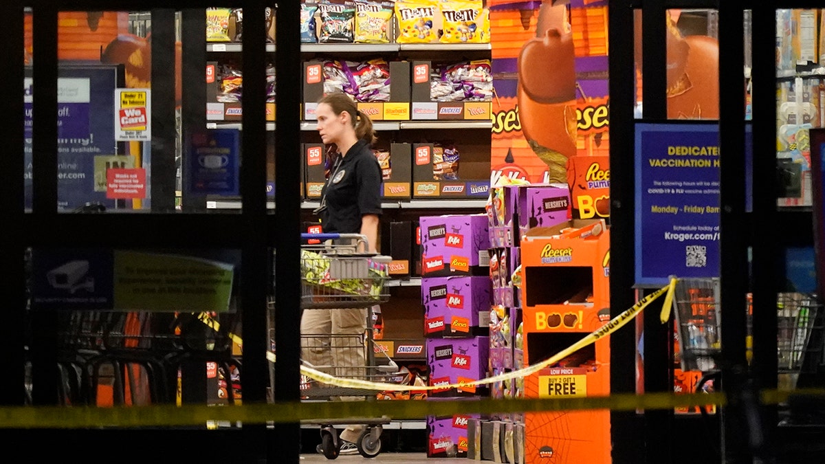 A responder walks down an aisle in a Kroger grocery store as the investigation goes into the night following a shooting earlier in the day on Thursday, Sept. 23, 2021, in Collierville, Tenn. (AP Photo/Mark Humphrey)