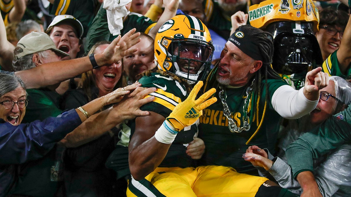 Aaron Jones does a Lambeau Leap after scoring a touchdown days after his father's death