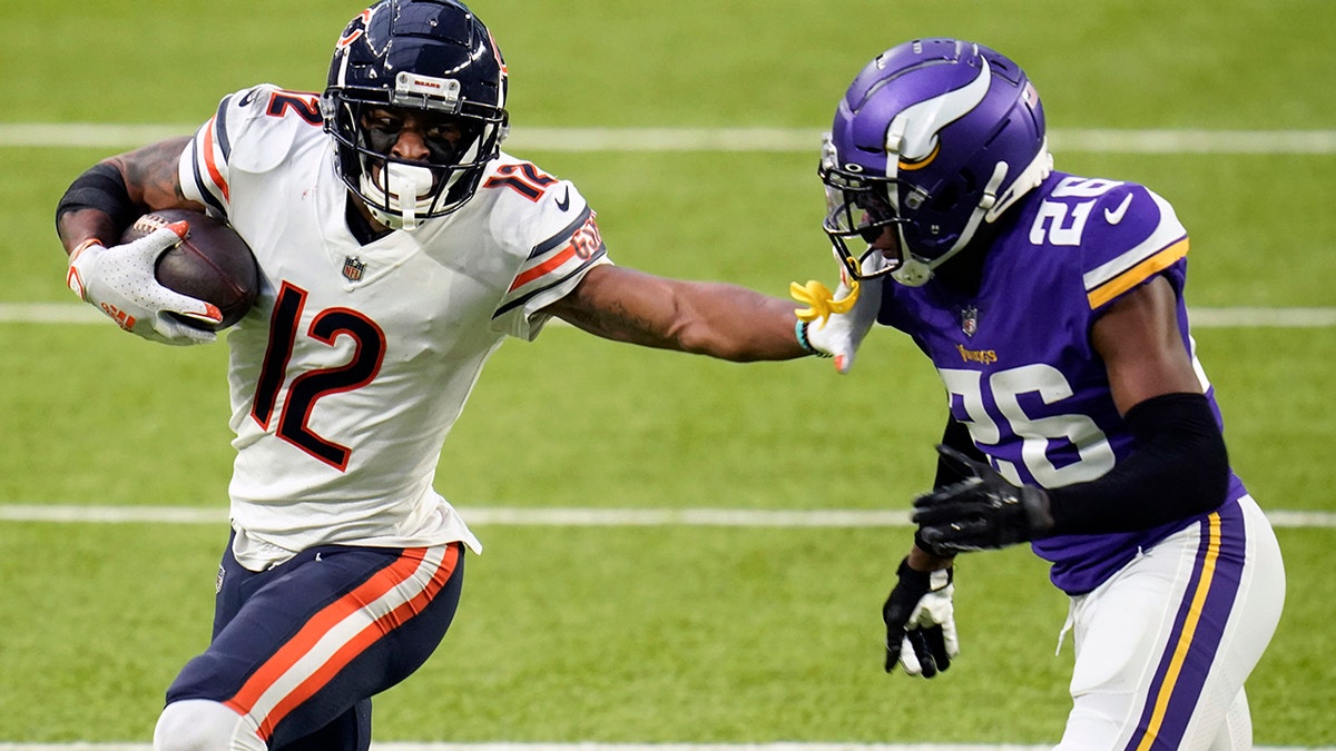 Chicago Bears wide receiver Allen Robinson II (12) runs from Minnesota Vikings cornerback Chris Jones (26) after catching a pass during the second half of an NFL football game Dec. 20, 2020, in Minneapolis. Robinson  insisted a contract negotiation that left him playing this season on the franchise tag rather than a multiyear deal did not give him a chip on his shoulder or an extra desire to show his worth. (AP Photo/Jim Mone, File)