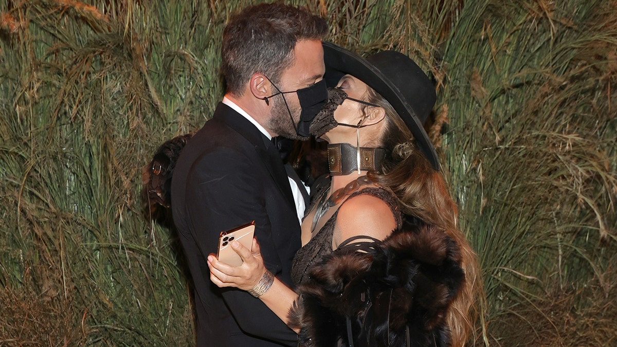 Ben Affleck and Jennifer Lopez share a kiss through their masks at the the 2021 Met Gala.