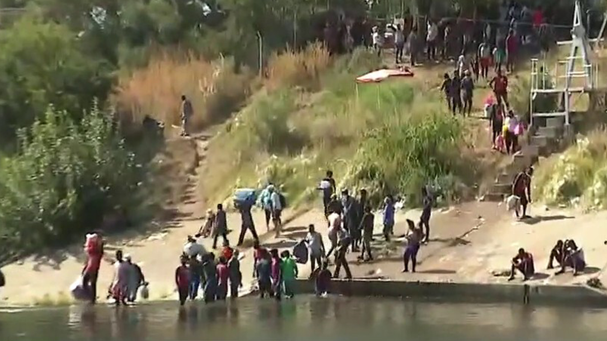 Migrants cross the Rio Grande river
