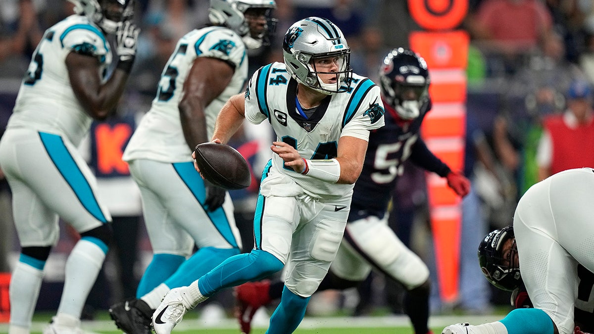 Carolina Panthers quarterback Sam Darnold (14) scrambles out of the pocket against the Houston Texans during the first half of an NFL football game Thursday, Sept. 23, 2021, in Houston. 