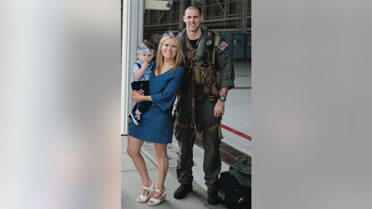 Naval Air Crewman (Helicopter) 2nd Class James P. Buriak, 31, from Salem, Virginia, with wife Megan, and son Caulder.