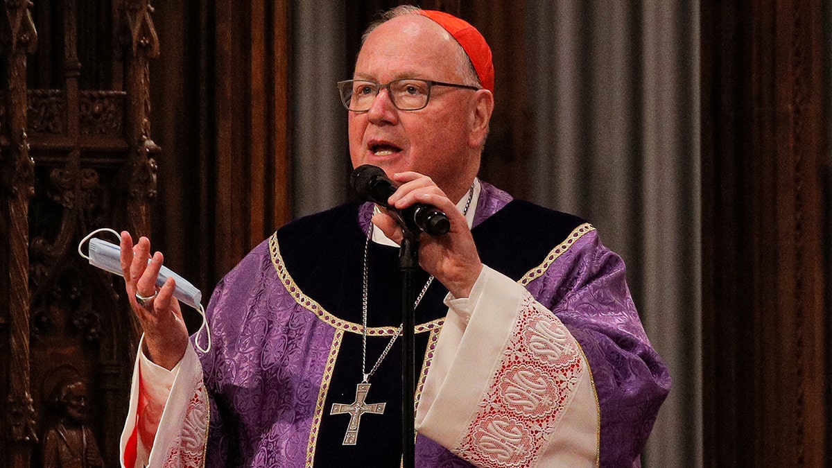 Cardinal Timothy Dolan preaching in robes and wearing a cross