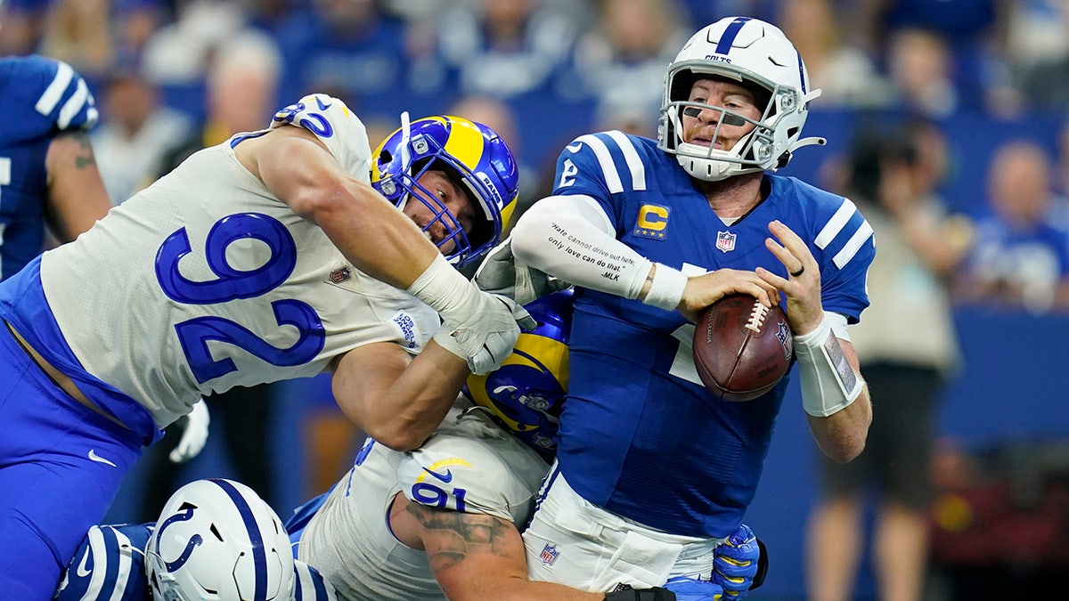 Indianapolis Colts quarterback Carson Wentz (2) is sacked by Los Angeles Ram Greg Gaines (91) during the first half of an NFL football game, Sunday, Sept. 19, 2021, in Indianapolis.