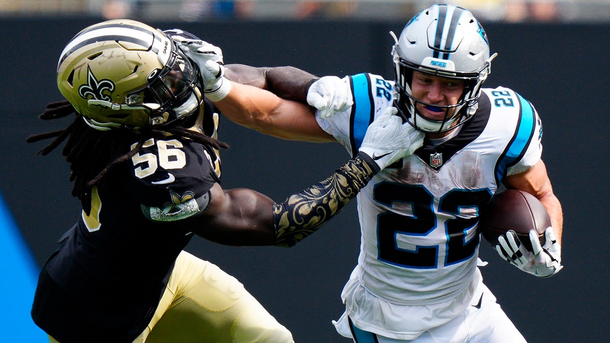 Carolina Panthers running back Christian McCaffrey pushes away from New Orleans Saints outside linebacker Demario Davis during the second half of a game Sunday, Sept. 19, 2021, in Charlotte, N.C. 