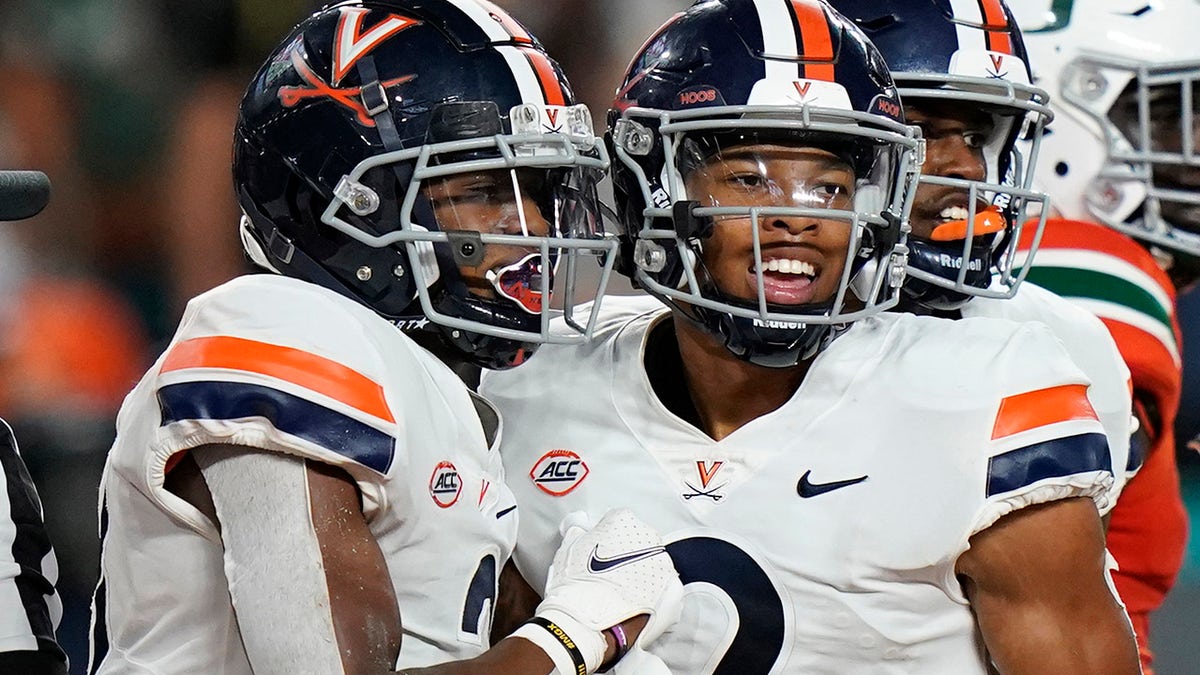 Virginia wide receiver Ra'Shaun Henry (2) congratulates wide receiver Dontayvion Wicks, after Wicks scored a touchdown during the second half of a NCAA college football game against Miami, Thursday, Sept. 30, 2021, in Miami Gardens, Fla.