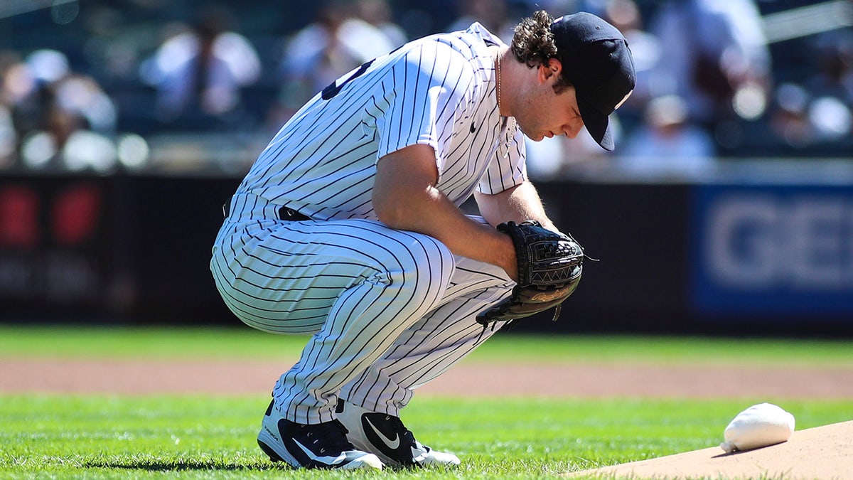 New York Yankees pitcher Gerrit Cole kneels before the start of the game against the Cleveland Indians at Yankee Stadium.