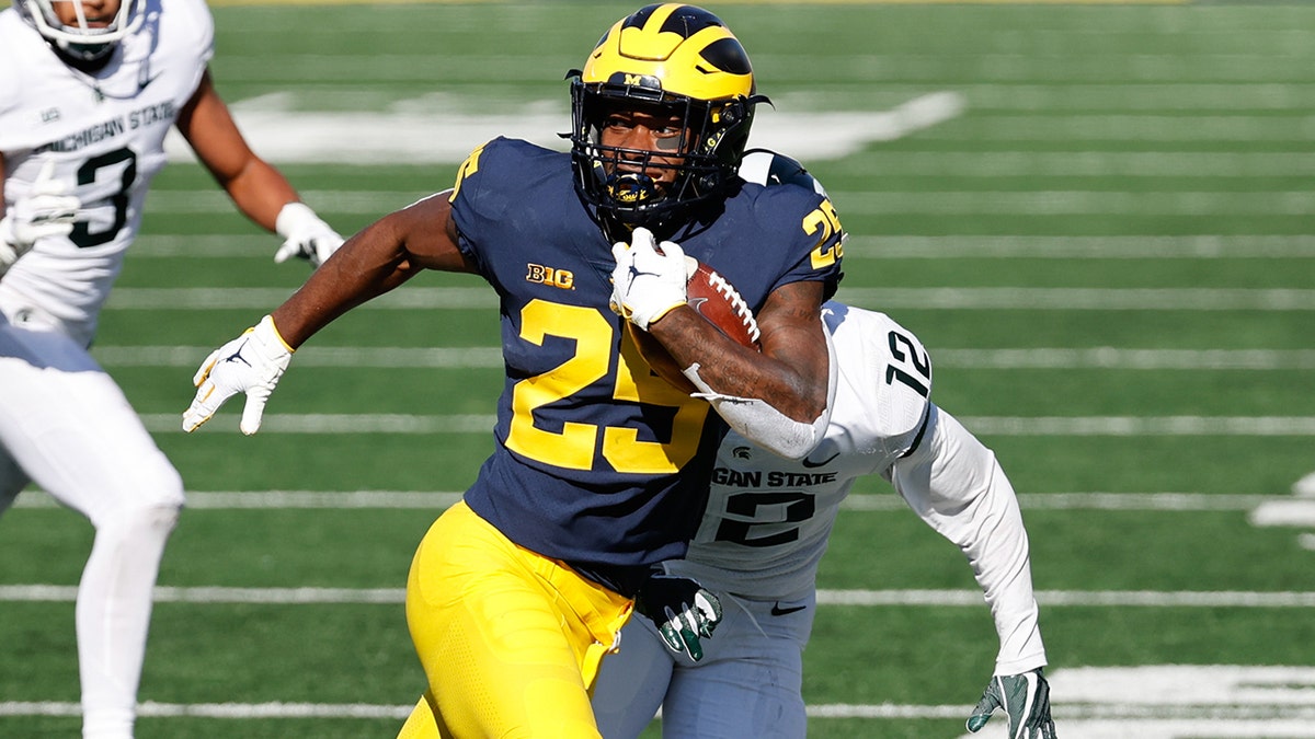 Michigan Wolverines running back Hassan Haskins rushes against the Michigan State Spartans at Michigan Stadium.