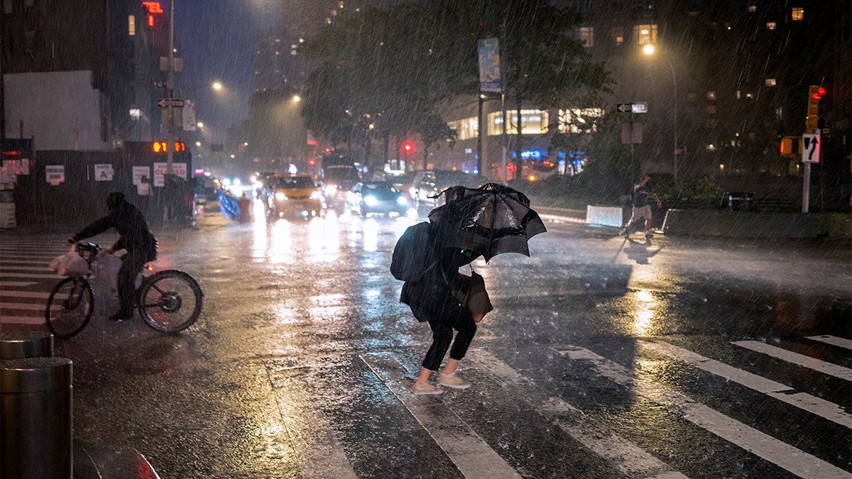 Pedestrians take cover near Columbus Circle in New York Wednesday, Sept. 1, 2021, as the remnants of Hurricane Ida remained powerful while moving along the Eastern seaboard. 