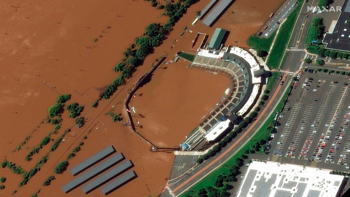 In a satellite image provided by Maxar Technologies, the stadium for the Somerset Patriots Double-A baseball team is partially flooded by overflow from the Raritan River on Thursday, Sept. 2, 2021, in Bridgewater Township, N.J., the day after torrential rain from the remnants of Hurricane Ida drenched the area. A railroad line to the left of the stadium is submerged. 