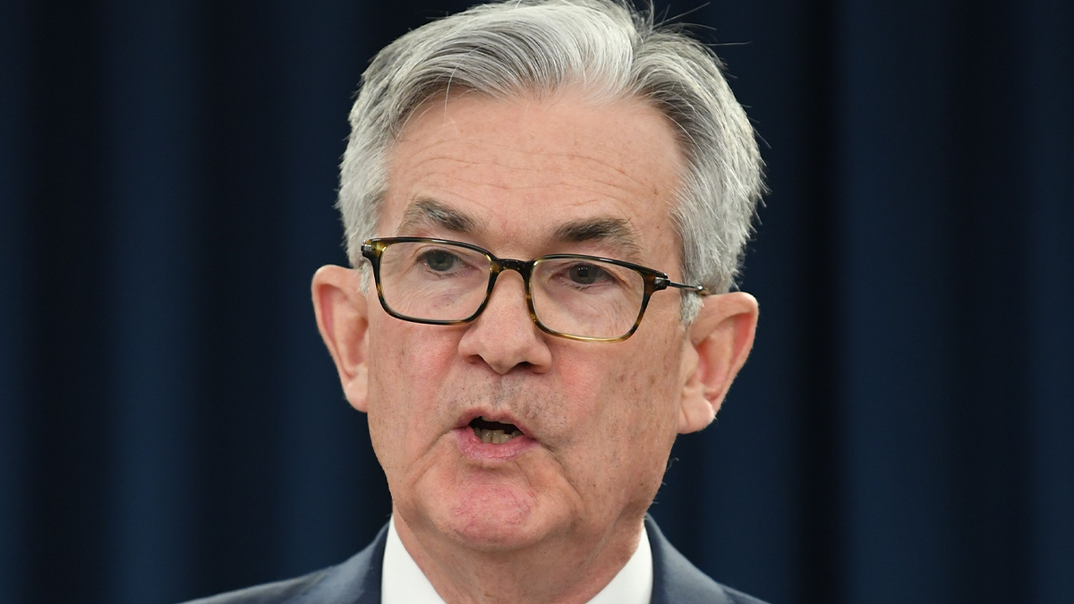 Federal reserve Chairman Jerome Powell in a suit speaks at news conference