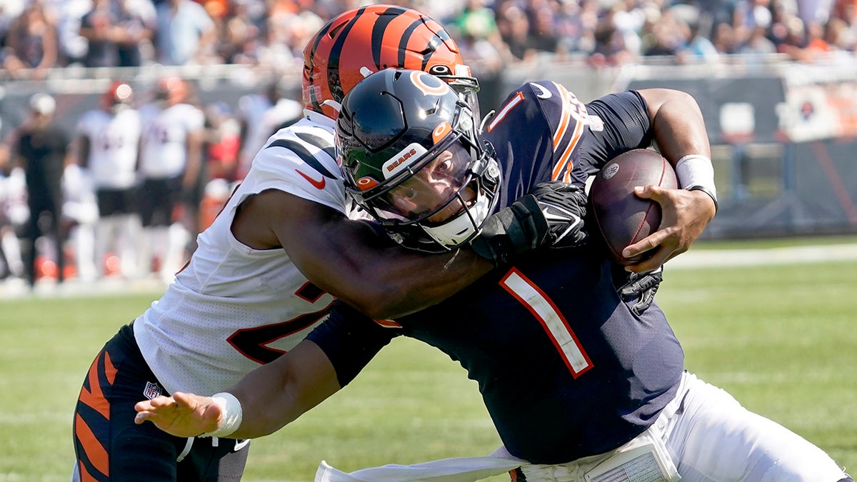Chicago Bears quarterback Justin Fields (1) carries the ball and is tackled by Cincinnati Bengals cornerback Chidobe Awuzie during the second half of an NFL football game Sunday, Sept. 19, 2021, in Chicago.