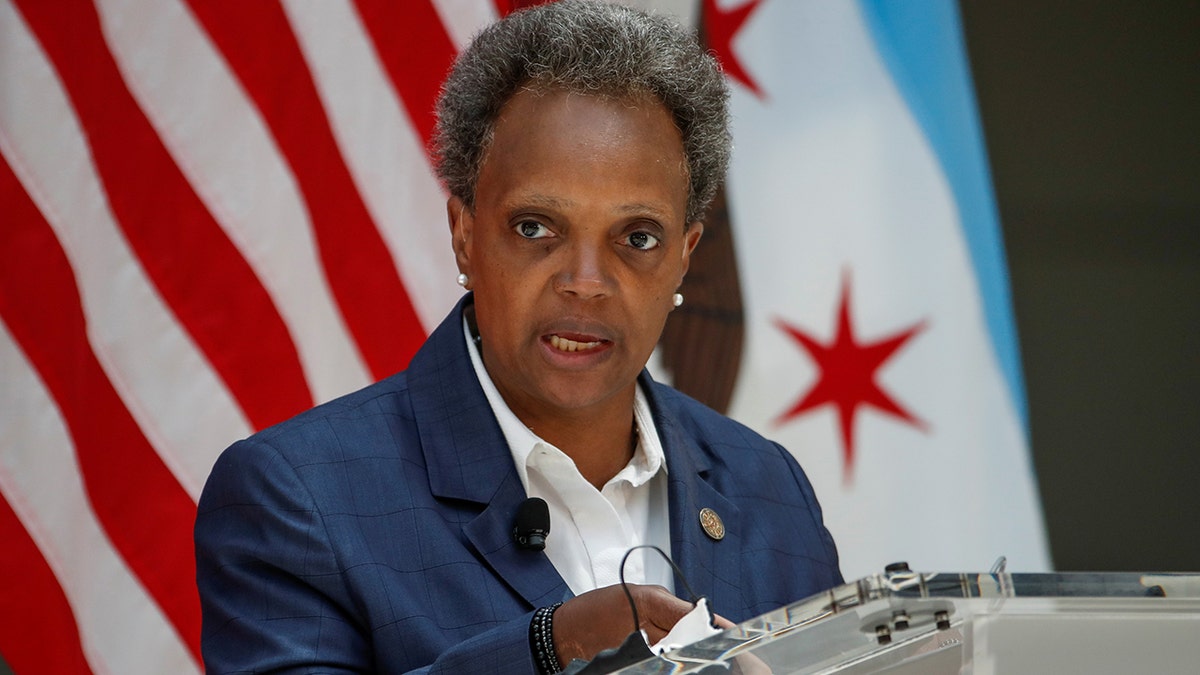 Photo showing Chicago Mayor Lori Lightfoot delivering reamrks in 2020 at a podium 