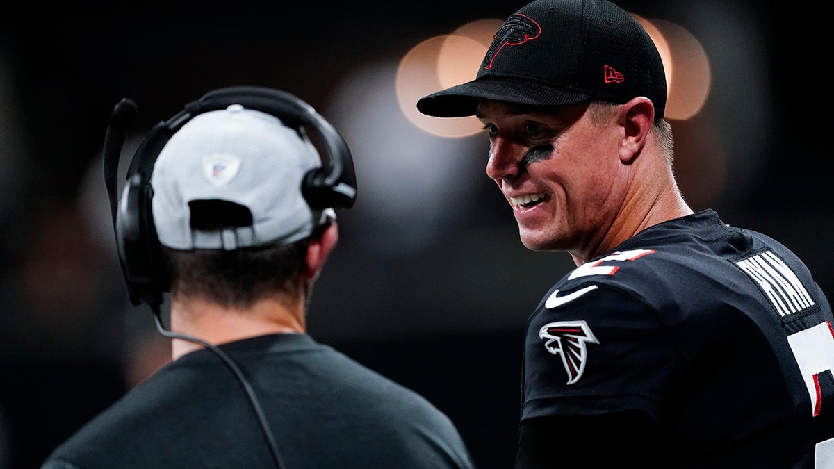 Atlanta Falcons quarterback Matt Ryan, right, stands on the sidelines during the first half of a preseason NFL football game against the Cleveland Browns, Sunday, Aug. 29, 2021, in Atlanta. (AP Photo/John Bazemore)