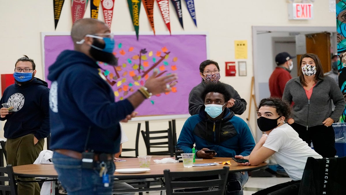 Students, teachers, administrators and counselors listen as principal Malik Lewis, foreground, second from left, teaches them a history lesson at West Brooklyn Community High School on Oct. 29, 2020, in New York.