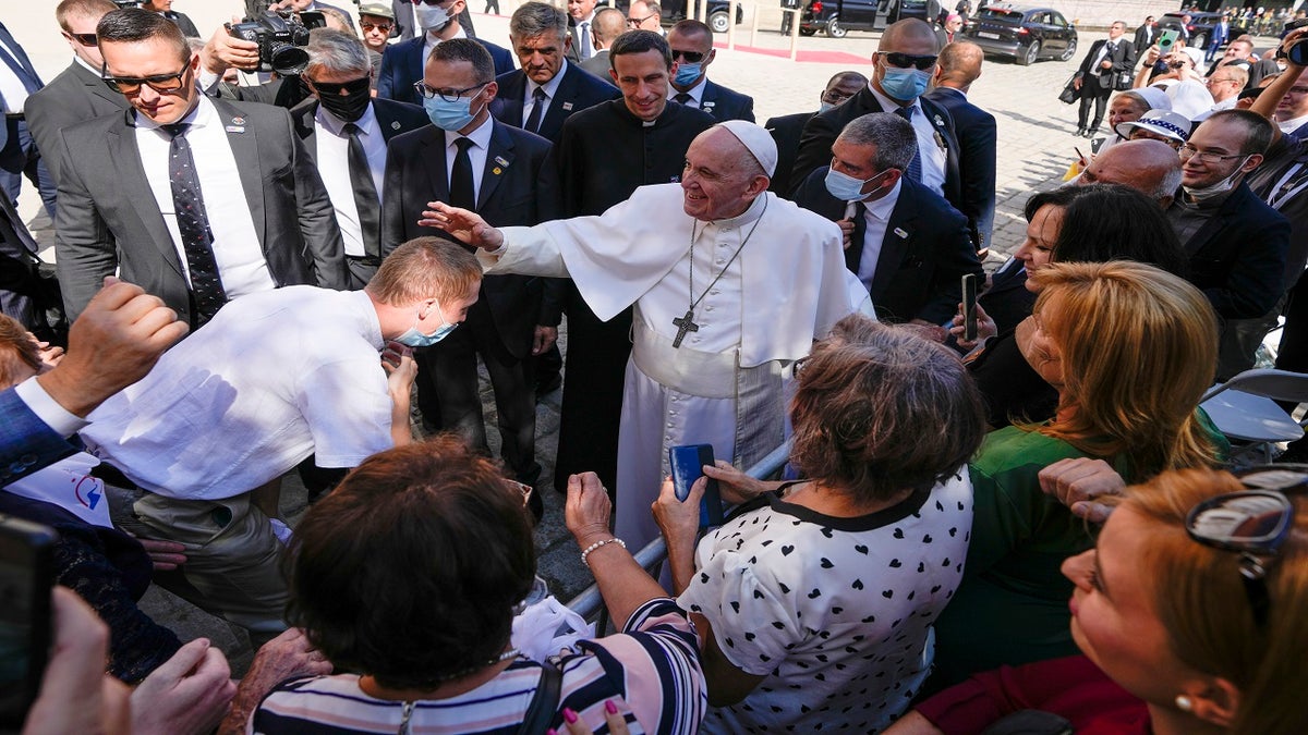 Pope Francis blesses an unidentified man as he greets the crowd while leaving the Cathedral of Saint Martin, in Bratislava, Slovakia, on Monday. (AP)
