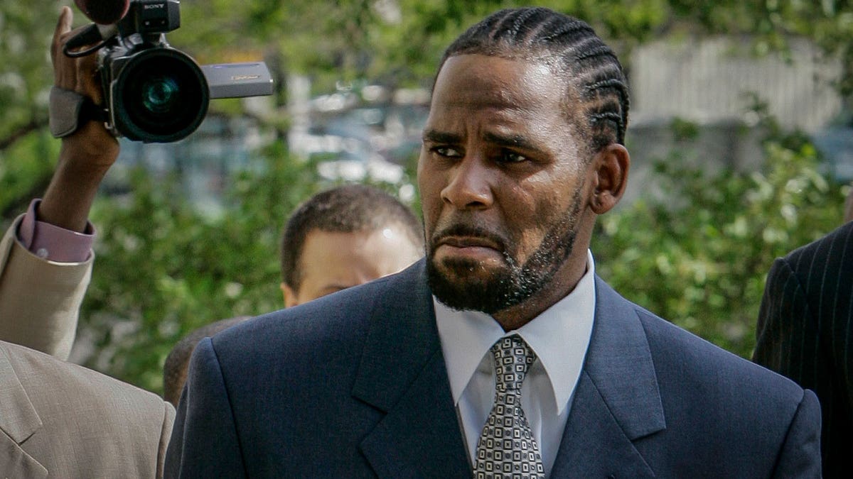 R. Kelly frowns outside court