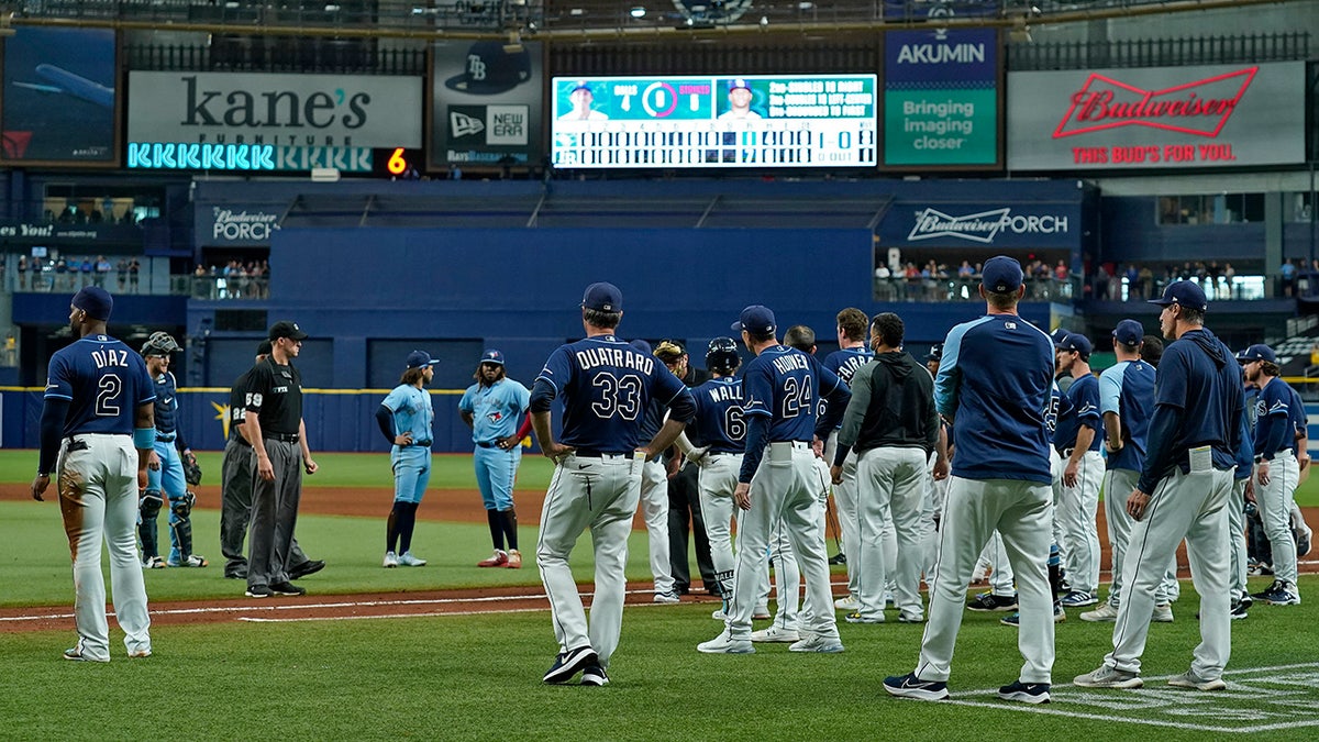 Tampa Bay Rays and Toronto Blue Jays players stand on the field after Blue Jays pitcher Ryan Borucki hit the Rays' Kevin Kiermaier with a pitch during the eighth inning of a baseball game Wednesday, Sept. 22, 2021, in St. Petersburg, Fla. 