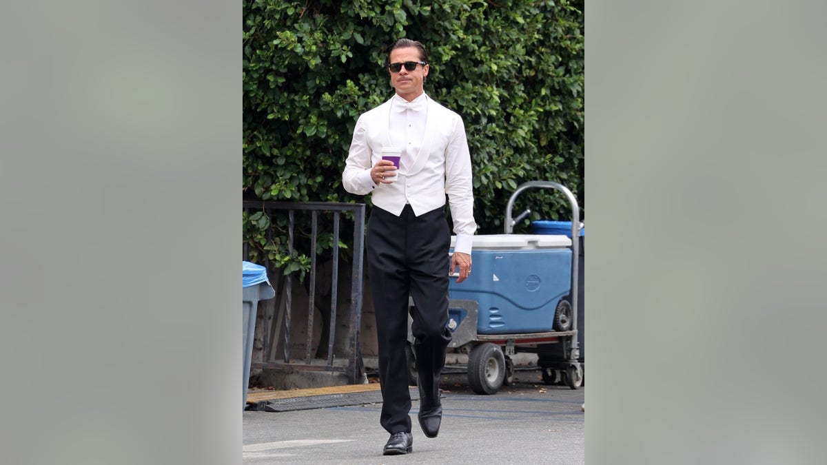 Brad Pitt filming sips on a coffee as he gets back to work on his latest film 'Babylon.' Brad looked dapper in a tuxedo outfit for today's scenes. Pitt stepped out briefly while filming an interior party scene for which he was dressed to the nines.