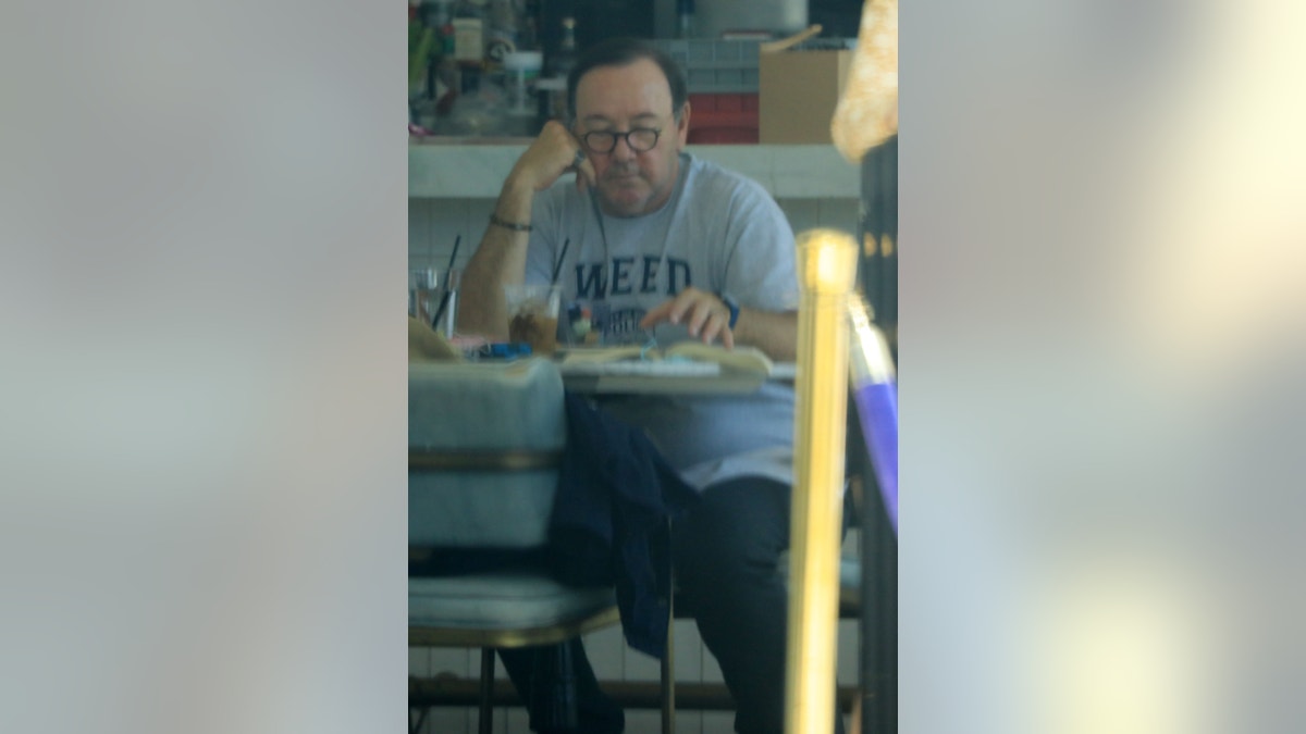 Spacey was seen reading from a book as he sat alone eating his lunch.