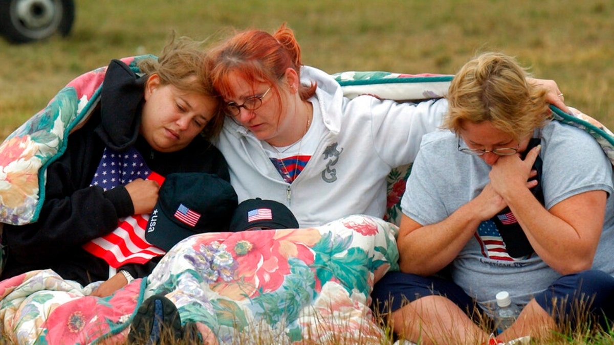 ADVANCE FOR PUBLICATION ON SUNDAY, SEPT. 5, AND THEREAFTER - FILE - In this Wednesday, Sept. 11, 2002 file photo, from left, Shannon Barry, Lisa Starr and Michelle Wagner, all of Hershey, Pa., comfort each other as they listen to a memorial service for victims of Flight 93 near Shanksville, Pa. President Bush will lay a wreath at the crash site later in the day to mark the anniversary of the terrorist attacks. 