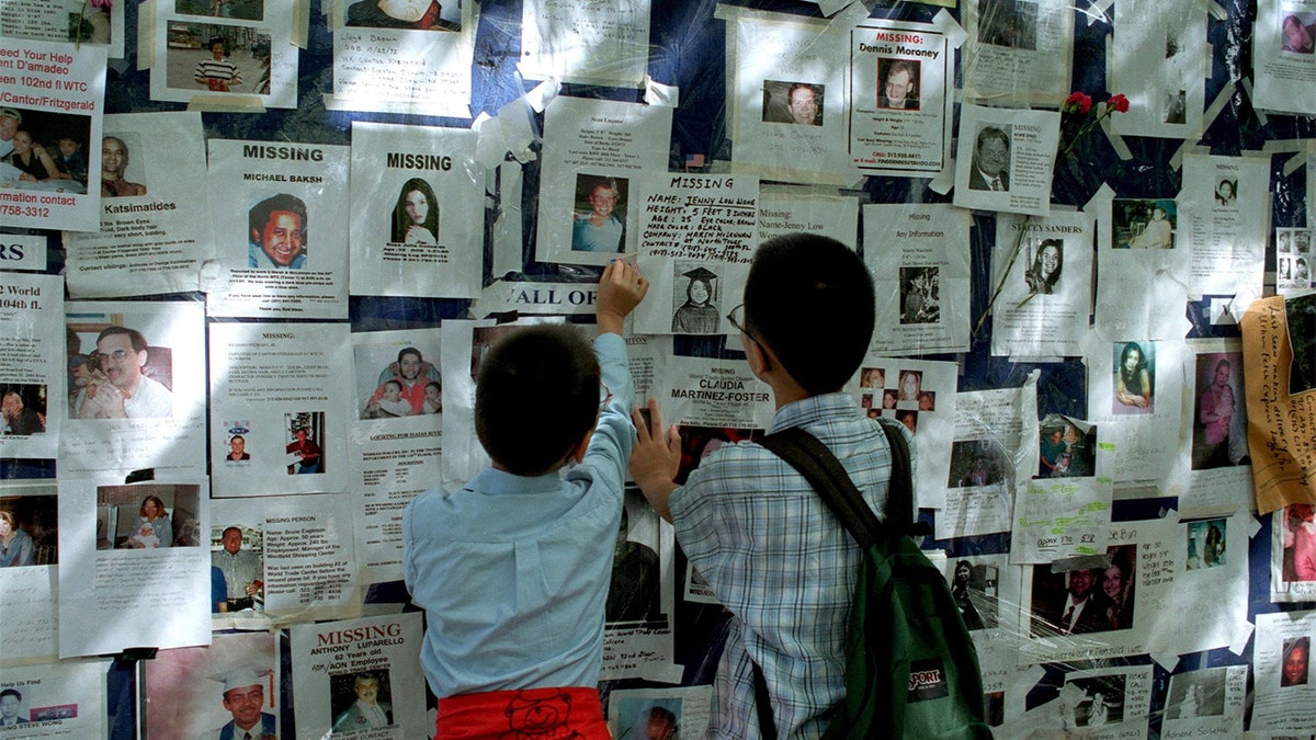Two boys look at a poster of missing people outside Bellevue Hospital in the week after 9/11/01