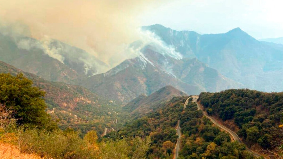 In this Sunday, Sept. 12, 2021 photo released by the KNP Complex Fire Incident Command, smoke plumes rise from the Paradise Fire in Sequoia National Park, Calif. In the southern Sierra Nevada, two fires ignited by lightning are burning in Sequoia National Park.?