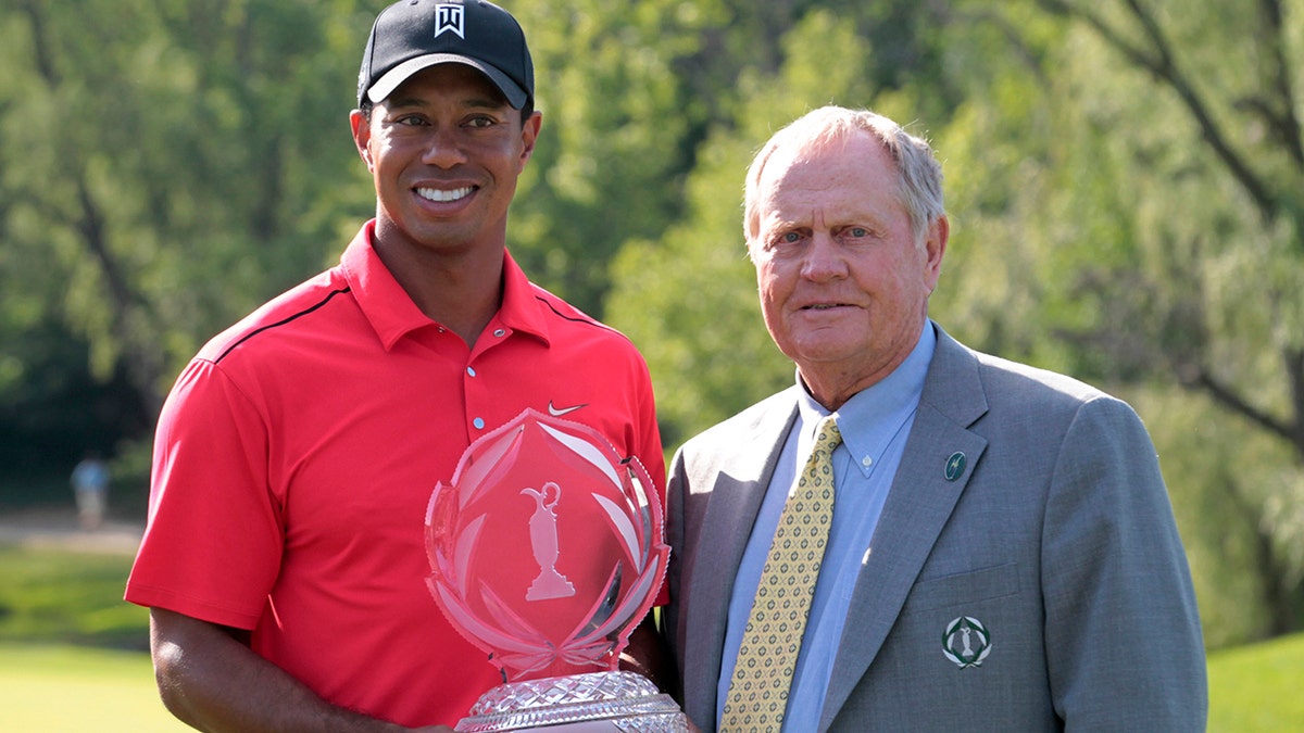 Tiger Woods of the U.S. holds the winners trophy with Jack Nicklaus (right) after winning the Memorial Golf Tournament at Muirfield Village Golf Club in Dublin, Ohio, June 3, 2012.
