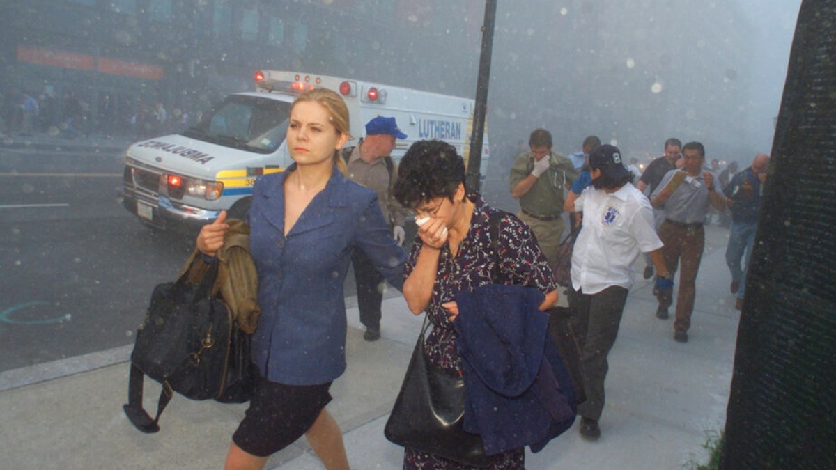 FILE - People flee from downtown Manhattan after planes crashed into the twin towers of the World Trade Center on September 11, 2001 in New York City. Associated Press photographer Richard Drew talks about AP’s coverage of 9/11 and the events that followed. 