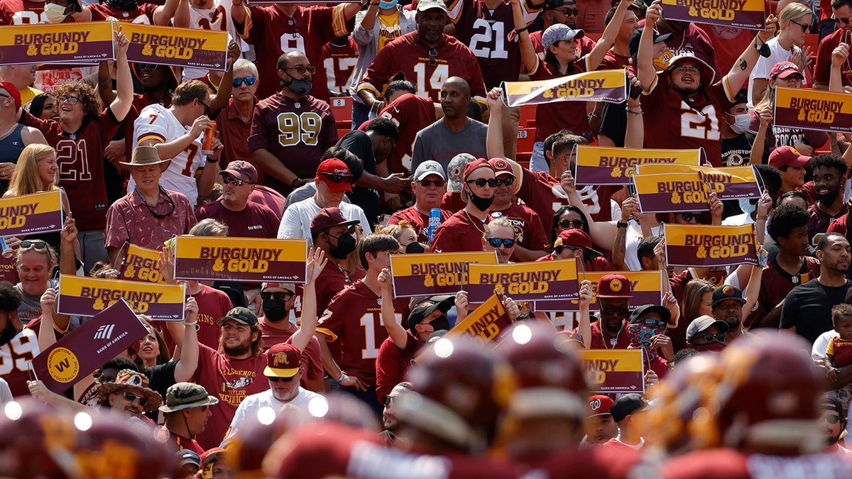 Washington Football Team fans hold signs in the stands against the Los Angeles Chargers in the first quarter at FedExField