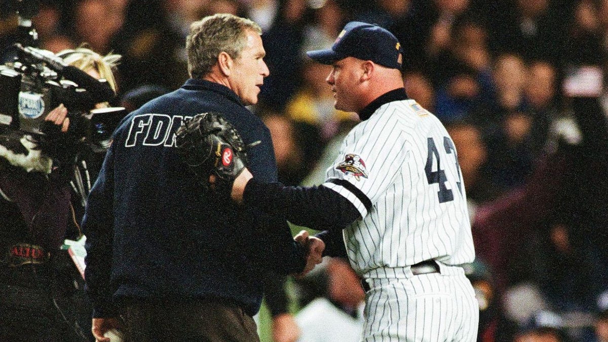 President George W. Bush shakes hands with New York Yankees catcher Todd Greene prior to throwing out the first pitch before Game Three of the World Series between the Arizona Diamondbacks and the New York Yankees on Oct. 30, 2001 at Yankee Stadium in Bronx, New York. (Photo by Sporting News via Getty Images via Getty Images)