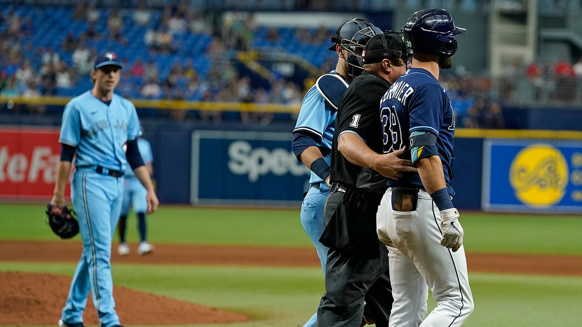 Tampa Bay Rays' Kevin Kiermaier, right, is held back by home plate umpire Bruce Dreckman and Toronto Blue Jays catcher Danny Jansen after Kiermaier was hit with a pitch by starting pitcher Ryan Borucki, right, during the eighth inning of a baseball game Wednesday, Sept. 22, 2021, in St. Petersburg, Fla. 