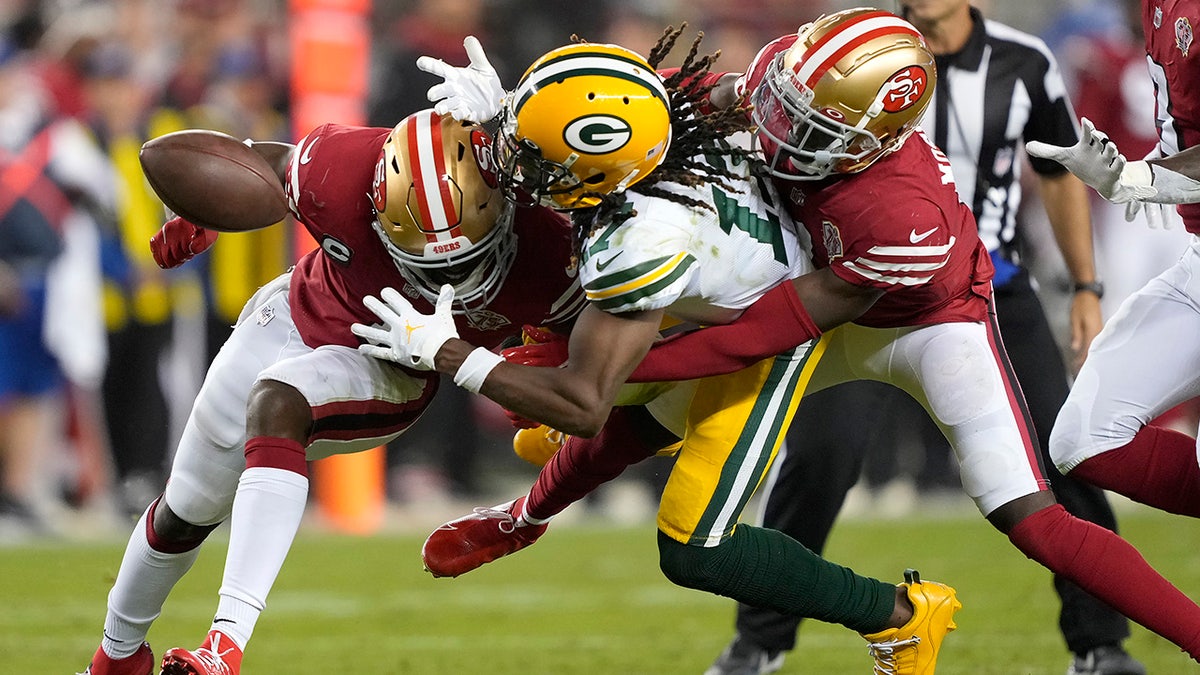 Green Bay Packers wide receiver Davante Adams, middle, cannot catch a pass between San Francisco 49ers cornerback Jimmie Ward, left, and defensive back Emmanuel Moseley during the second half of an NFL football game in Santa Clara, California, Sunday, Sept. 26, 2021. 