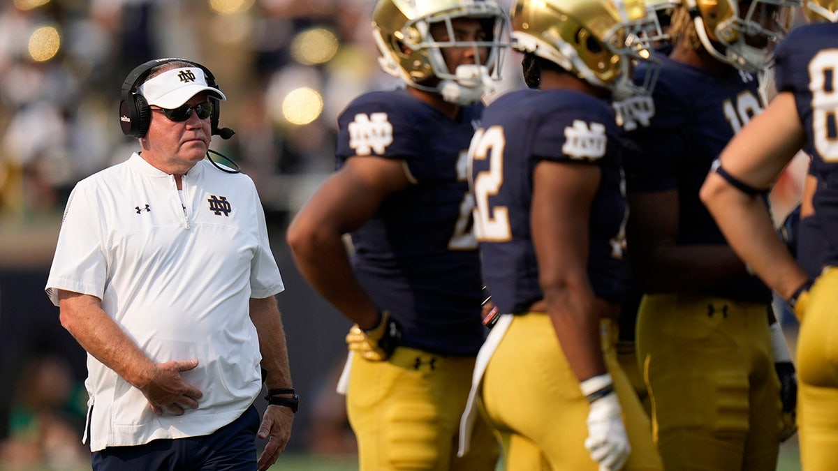 Notre Dame head coach Brian Kelly walks to a huddle as his team plays Toledo in the second half of an NCAA college football game in South Bend, Indiana, Saturday, Sept. 11, 2021. Notre Dame won 32-29.