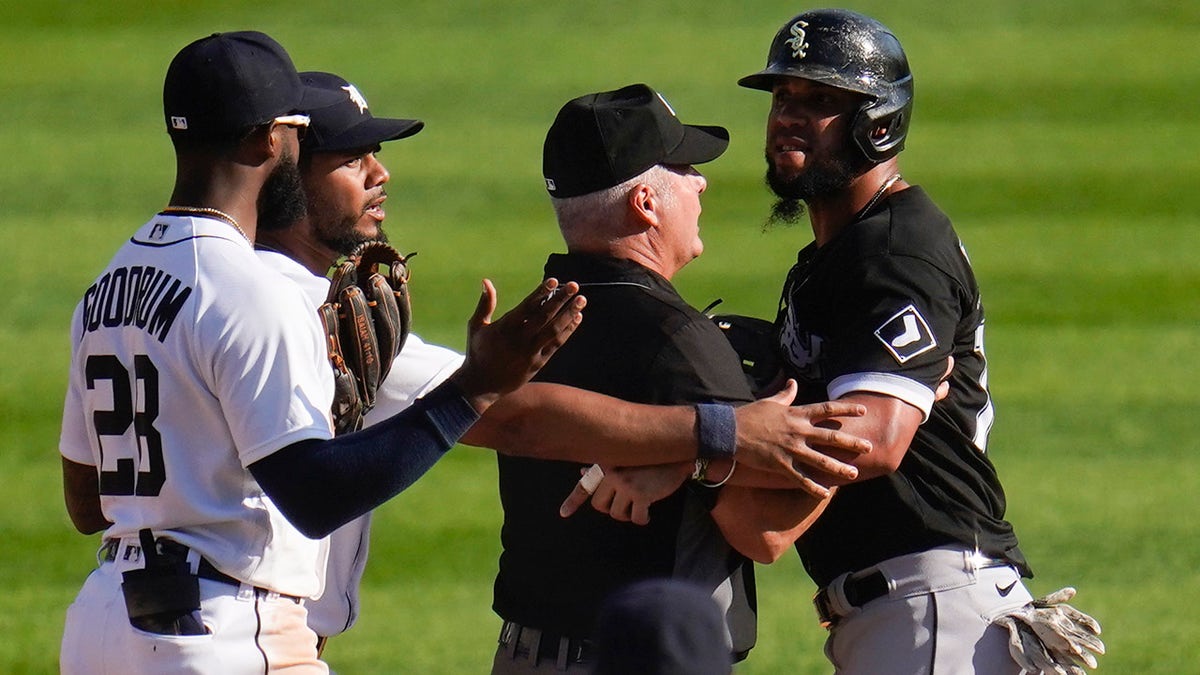 Chicago White Sox's Jose Abreu, right, is held back by second base umpire Tim Timmons from Detroit Tigers shortstop Niko Goodrum (28) as Jeimer Candelario, second from left, tries to help in the ninth inning of a baseball game in Detroit, Monday, Sept. 27, 2021.