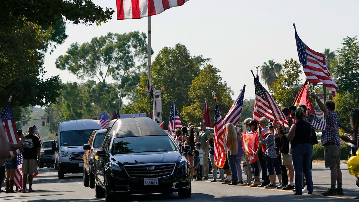 A hearse carrying the body of United States Marine, Lance Cpl. Kareem M. Nikoui makes its way among the main thoroughfare Friday, Sept. 17, 2021, in Norco, Calif. Nikoui along with ten additional Marines, one Navy corpsman and one soldier were killed Aug. 26, 2021, as the result of an enemy attack while supporting evacuation operations outside the Hamid Karzai International Airport Kabul, Afghanistan. (AP Photo/Marcio Jose Sanchez)