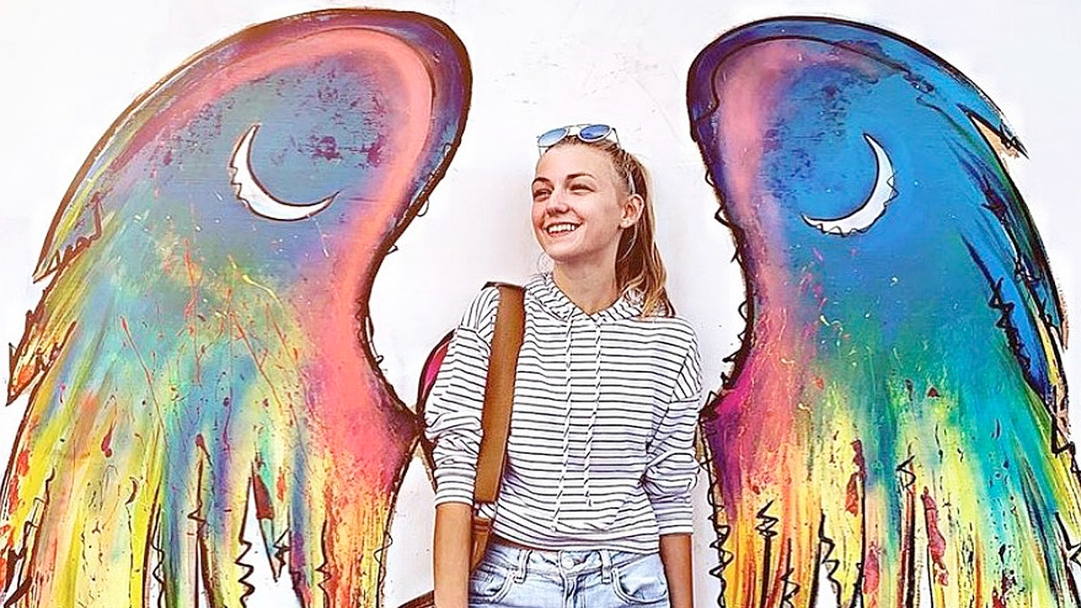 Gabby Petito poses in front of painted wings