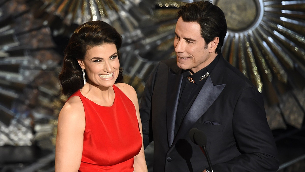 John Travolta (R) and Idina Menzel present an award on stage at the 87th Oscars February 22, 2015 in Hollywood, California.